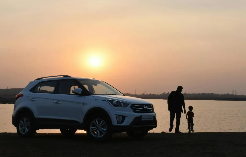 Rodinné auto, pravděpodobně SUV, parkuje před domem s rodinou. Je to jeden z modelů, které patří mezi nejoblíbenější rodinná auta v ČR.