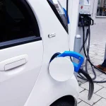 Moderní rychlonabíjecí stanice pro elektromobily v České republice, s logy poskytovatelů a zeleným okolím, zdůrazňující rozvoj infrastruktury.