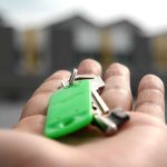 Person, die Schlüssel für ein Mietobjekt aushändigt.