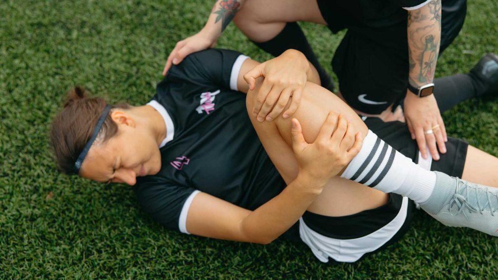 Ein verletzter Fußballspieler liegt auf dem Feld.
