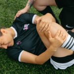 Ein verletzter Fußballspieler liegt auf dem Feld.