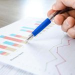 Ein Mann analysiert auf Papier gedruckte Daten.