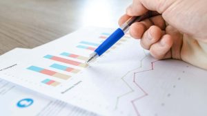 Ein Mann analysiert auf Papier gedruckte Daten.
