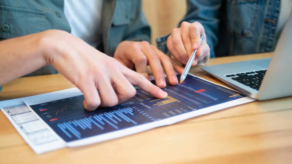 Mitarbeiter analysieren Big Data-Blätter mit Diagrammen.