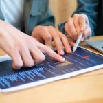 Mitarbeiter analysieren Big Data-Blätter mit Diagrammen.