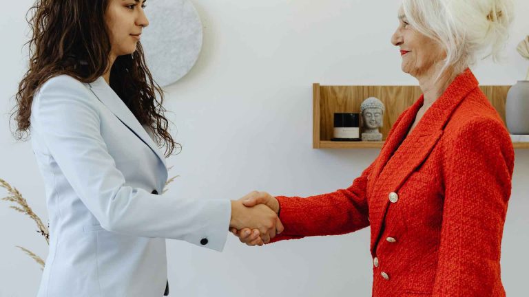 Zwei Frauen schütteln zustimmend die Hände.