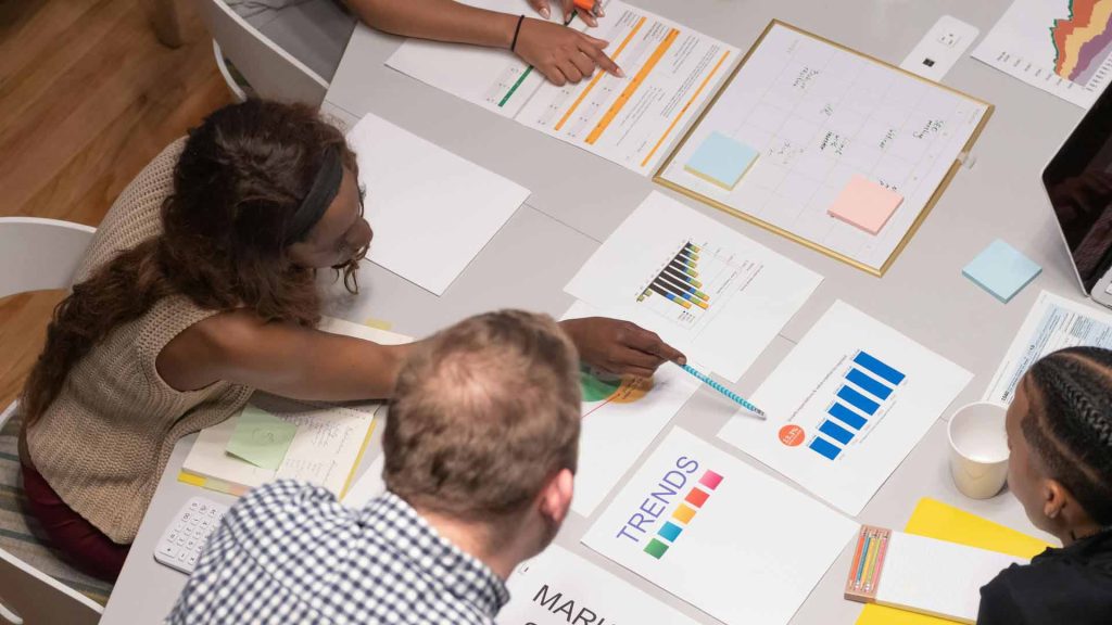 Ein Team in einem Unternehmen analysiert Diagramme, um das Vertriebsmanagement zu verstehen.