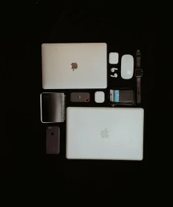 Et udvalg af innovative enheder og tilbehør, der repræsenterer nyttige gadgets udover smartphones på et moderne skrivebord.