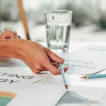 Forretningsfolk diskuterer finansielle dokumenter. De analyserer skatteændringer for virksomheder og planlægger tilpasning.