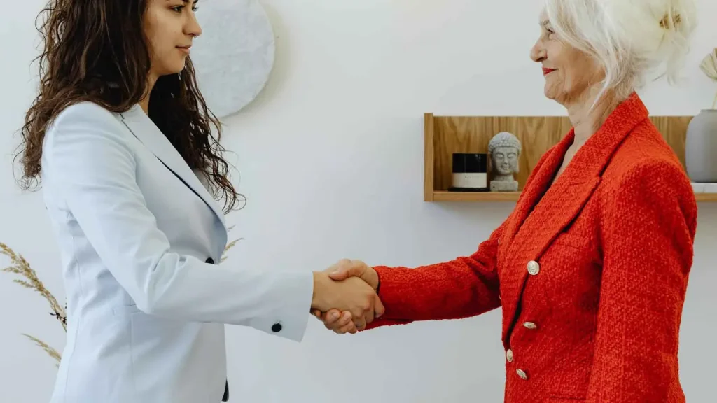 Una pareja sonriente revisa documentos importantes en una mesa, siguiendo Consejos para buscar piso y firmar contrato de alquiler de forma informada.