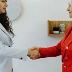 Una pareja sonriente revisa documentos importantes en una mesa, siguiendo Consejos para buscar piso y firmar contrato de alquiler de forma informada.