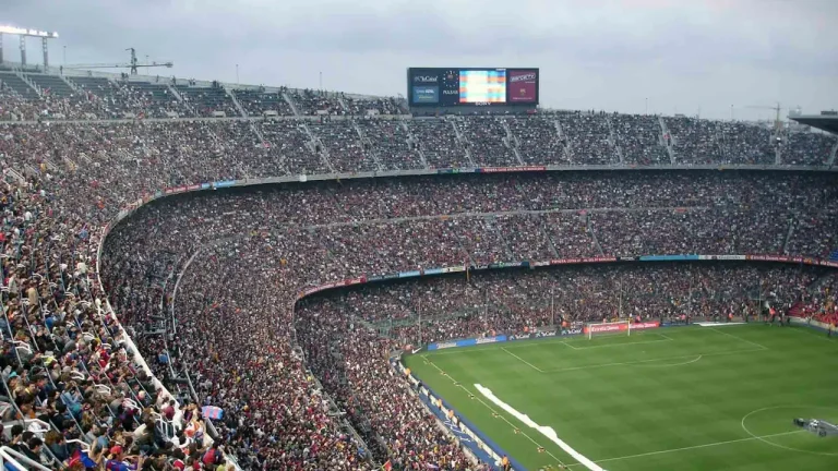 Voluntarios organizan equipos en un estadio moderno, simbolizando la meticulosa preparación y el impacto económico de grandes eventos deportivos.