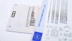 Pila de documentos esenciales para tu vehículo, como la licencia de conducir, tarjeta de registro y seguro, cuidadosamente apilados en una mesa.