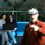 Henkilö syventyneenä virtuaalitodellisuuslasien läpi interaktiiviseen ympäristöön, esitellen virtuaalitodellisuuden hyödyntämistä oppimisessa ja viihteessä.