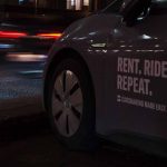 Un véhicule d'une société d'autopartage circulant dans une rue la nuit.