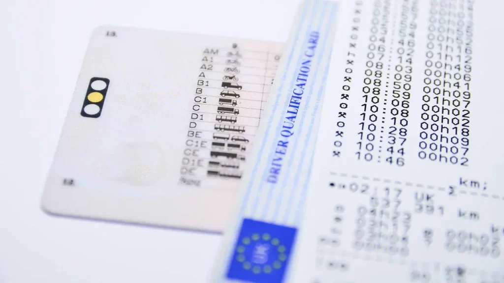 Ένας σωρός από επίσημα έγγραφα και ένα στυλό πάνω σε ένα γραφείο, συμβολίζοντας την προετοιμασία των απαραίτητων εγγράφων για αγορά και κατοχή αυτοκινήτου.