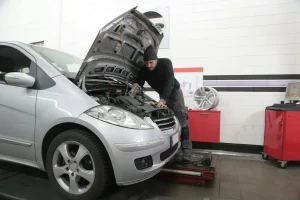 Vīrietis rūpīgi pulē automašīnas virsbūvi, nodrošinot auto kopšanu ilgmūžībai un spīdīgu izskatu.