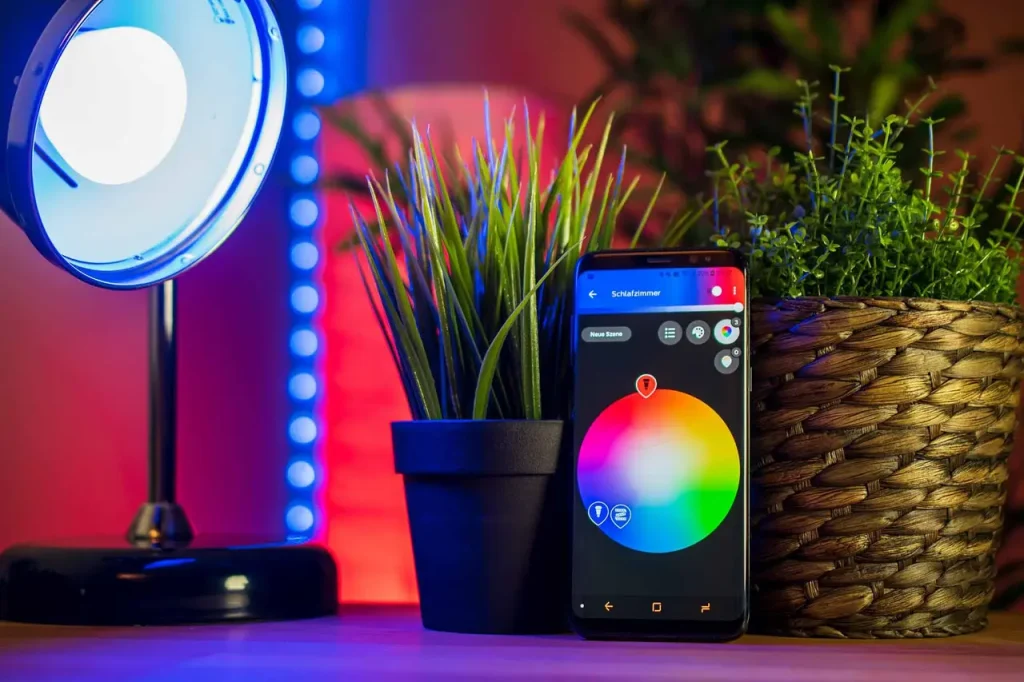 Diverse dispozitive smart home: termostat, boxă vocală și priză inteligentă, aranjate clar pe o masă.