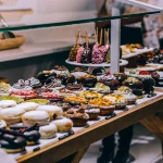 Wnętrze tętniącej życiem piekarni z półkami pełnymi świeżego, złocistego pieczywa. Idealne miejsce, aby znaleźć najlepszą piekarnię w Katowicach.